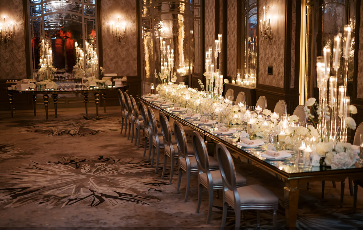 Elegant wedding decor setup featuring crystal chandeliers, gold chairs, floral vases, and candlelight — available for rental in Paris.